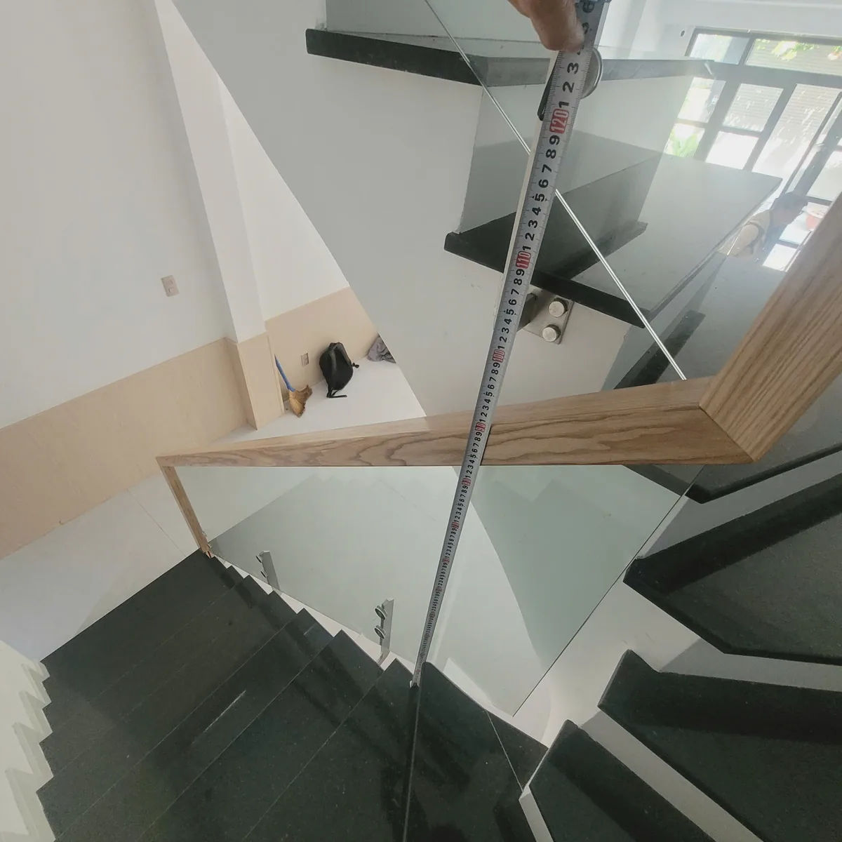 Kỹ thuật viên đo kiểm tra lan can kính cầu thang khi khảo sát